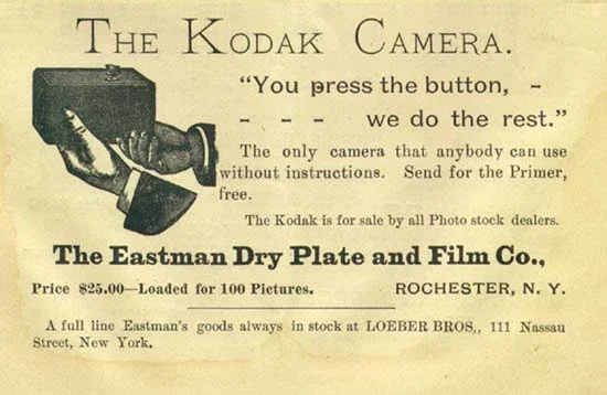 An early newspaper advertisement for the Kodak camera: a hand holding a small box camera beside the slogan “You press the button, we do the rest,” with the line “The only camera that anybody can use without instructions” and a price of $25.00.