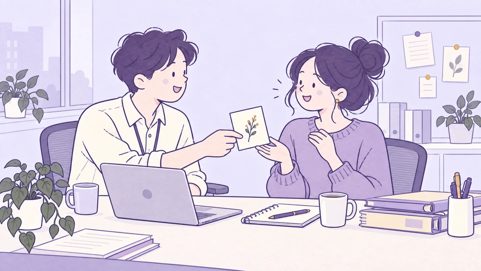 Two coworkers sharing a thank-you card with a botanical sprig across an office desk, beside a laptop, notebooks, and mugs.